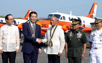 <p><strong>AIRCRAFT DONATION.</strong> Department of National Defense (DND) Secretary Delfin Lorenzana (middle) shakes hands with Parliamentary Vice Minister of Defense Tatsuo Fukuda (2nd from left) during the turn over of the three Beechcraft King Air TC-90 patrol aircrafts in a brief ceremony at the Naval Air Group headquarters in Cavite City on Monday (March 26, 2018). Also in the photo are Japanese Ambassador to the Philippines Koji Haneda (left), and Armed Forces of the Philippines (AFP) Chief of Staff General Rey Leonardo Guerrero (2nd from right). The planes were donated by the Japan Ministry of Defense to the Philippine Navy. <em>(PNA photo by Joey Razon)</em></p>